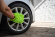 A Man Cleaning the Wheels of a Car with a Microfiber Wash Mitt. Car Detailing and Cleaning Concept with Space for Copy