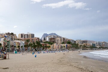 Canvas Print - Sea waves splashing over the shore with the city in the background, Alicante, Spain