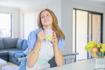 Wall Mural - エプロン姿でコーヒーを飲みながら会話する白人女性