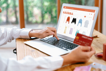 Woman shopping online on internet marketplace browsing for sale items for modern lifestyle and use credit card for online payment from wallet protected by uttermost cyber security software