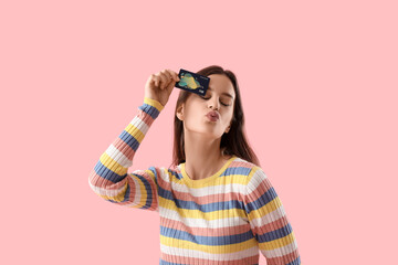 Sticker - Young woman with credit card blowing kiss on pink background