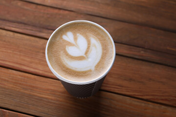 Wall Mural - Coffee to go. Paper cup with tasty drink on wooden table, above view