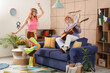 © Pixel-Shot - Couple of hippies playing guitar at home