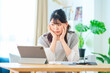 © maru54 - 部屋でパソコン作業をしながら疲れた表情の若い女性