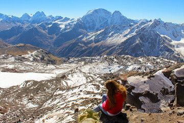 Wall Mural - The girl with the red hair flying on the wind sitting and enjoying the mountains