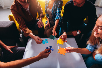 Wall Mural - Businessmen working together to build a puzzle as teamwork, partnership and integration concept