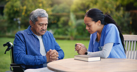 Wheelchair, praying or nurse with senior man for care, support or trust in retirement or nature. Caregiver, help and person or elderly patient with a disability or medical professional for worship