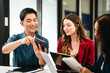 © Phushutter - Diverse group of professionals engaging in discussion with laptop and clipboard, in bright office environment. qualified auditor report and opinion, asian people, african american, caucasian female