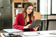 © Phushutter - Caucasian businesswoman, likely an accountant or CPA, smiling and holding a coffee cup while working on her laptop.