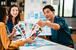 © Phushutter - diverse team of professionals engaged in a website graphic design board meeting, sharing opinions on UX and UI design elements. Asian man, African American people, black, afro, caucasian female