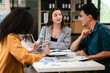 © Phushutter - diverse team of professionals engaged in a website graphic design board meeting, sharing opinions on UX and UI design elements. Asian man, African American people, black, afro, caucasian female