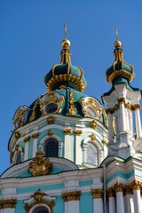 Wall Mural - St. Andrew's church domes with golden cross on blue sky background. Kyiv city, Ukraine