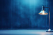 © Vovmar - Table lamp on a blue table against the background of a blue wall. Generated by artificial intelligence