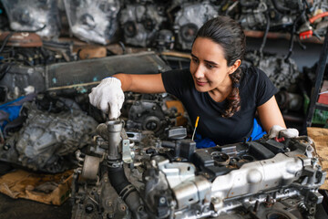 Female auto mechanic are repair and maintenance auto engine is problems. Engineer inspecting motor part problems. Woman empowerment working in automotive maintenance service industry.