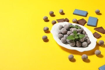 Sticker - Chocolate balls in a white bowl on a yellow background