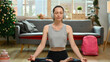 © Prathankarnpap - Beautiful young caucasian woman practicing yoga at home during Christmas time
