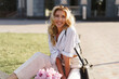 © Svetlana Sokolova - Elegant beautiful cheerful  blond woman in   stylish casual outfit  , holding  pink boquet with pions flowers. Posing on the street.