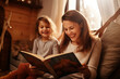 © Maximilien - Joyful Storytime: Preschool Girl and Mom Share Laughter in Reading Session