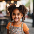 Smiling cute little african american girl with two pony tails looking at camera, ai technology