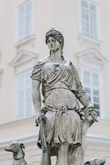 Old statue of the hunting goddess Diana with two dogs. The historical center of Lviv near the town hall on the square in Lviv, Ukraine.