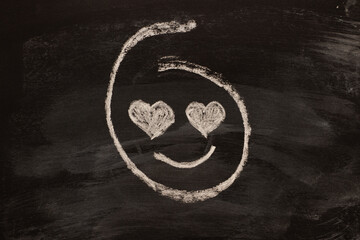 Wall Mural - Love emoticon looking with eyes hearts, chalk drawing on black board.