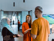 © .shock - A group of young business colleagues, including a woman in a hijab, stands united in the modern corridor of a spacious startup coworking center, representing diversity and collaborative spirit