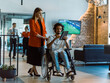 © .shock - African-American businessman in a wheelchair engages in a collaborative discussion, using a tablet, with his business colleague, exemplifying the seamless integration of adaptive technology and