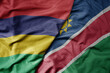 big waving national colorful flag of mauritius and national flag of namibia .
