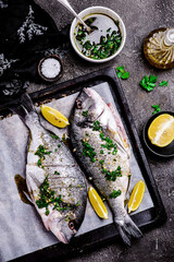 Wall Mural - Grilled dorado with herbs on a platter and baked potatoes..style rustic