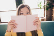 © deagreez - Close up photo of crazy funky teenager girl holding planner copybook hiding half face reading her plans isolated at home on background