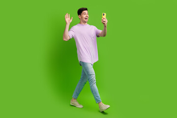 Sticker - Full length photo of cheerful man dressed trendy clothes speaking video call isolated on green color background