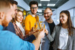 © maxbelchenko - Colleagues in the office celebrate the concluded deal with champagne and sparkling wine. A group of people with glasses of champagne having fun, relaxing in the office. Concept of work, holiday.