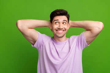 Sticker - Photo of positive glad man wear purple trendy clothes hold arms behind head look up empty space isolated on green color background