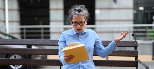 Sticker - Confident businesswoman, holding paperwork, epitomizes professionalism in a modern office, reflecting success and experience.