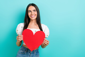 Poster - Portrait of young woman hold paper heart figure dreaming looking empty space red symbol subscribe channel isolated on blue color background