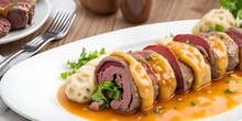 Rouladen Is A German Main Dish, Pickles And Bacon Wrapped In Thin Slices Of Beef, Or Veal, Served With Gravy, Dumplings, Mashed Potatoes, And Cabbage