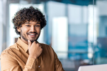 Wall Mural - Portrait of young successful businessman inside office at workplace, hispanic smiling and looking at camera, male programmer happy with achievement results.