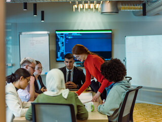 Wall Mural - A diverse team of business experts in a modern glass office, attentively listening to a colleague's presentation, fostering collaboration and innovation