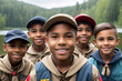 Group of five boy scouts posing. Mountains, lake and forest in the background. Racial diversity