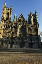 There Is A Large Stone Cathedral With Two Towers And A Green Spire