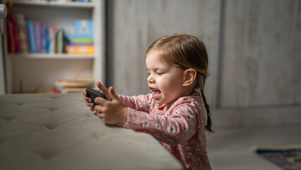 One girl toddler child play video game on mobile phone smartphone