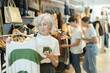 © JackF - elderly lady carefully examines selection of sweaters, searching for ideal one to keep her warm.