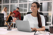 © New Africa - Team of employees working together in office. Happy woman with laptop at table indoors