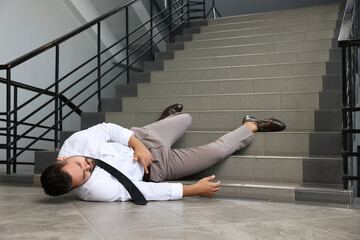 Man fallen down stairs suffering from pain indoors, space for text