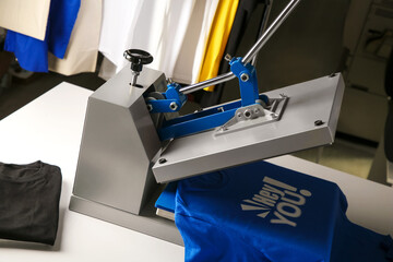 Wall Mural - Printing logo. Heat press with blue t-shirt on white table