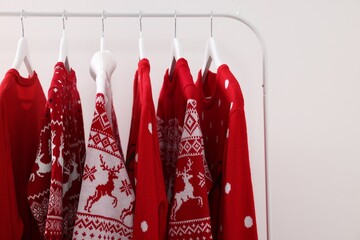 Wall Mural - Rack with different Christmas sweaters on white background