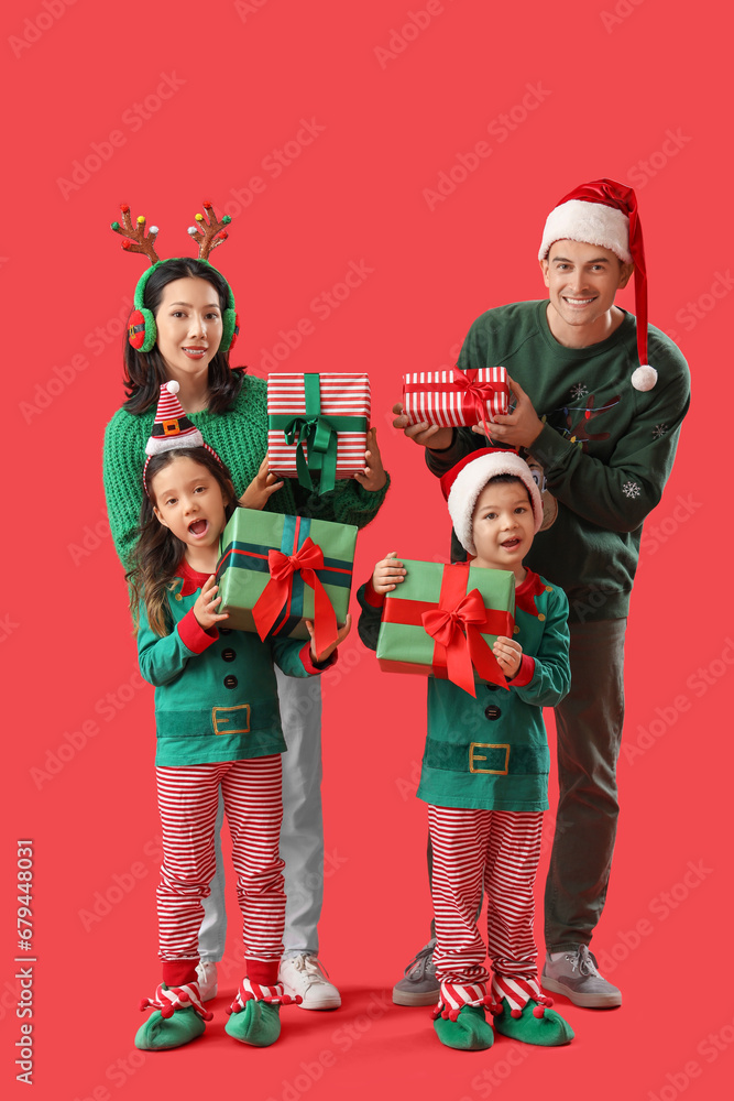 Happy family with Christmas presents on red background