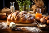 Fototapeta  - A freshly baked, golden brown brioche loaf on a rustic wooden table, surrounded by ingredients like eggs, flour, and butter, with a warm, inviting kitchen background