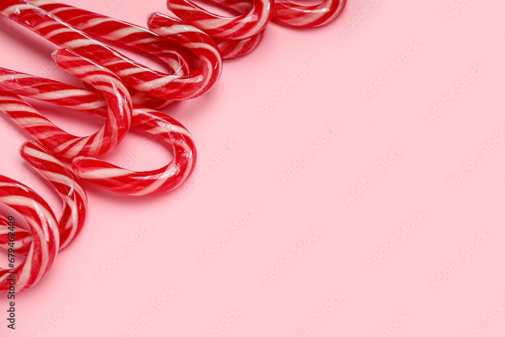 Many Christmas candy canes on pink background