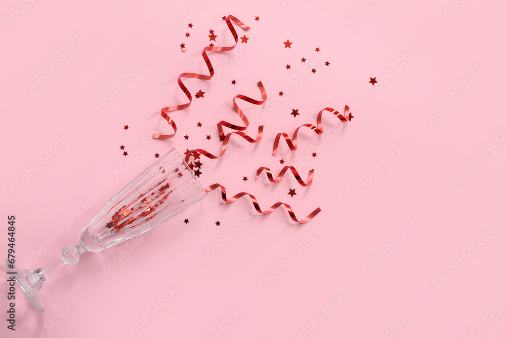 Champagne glass with Christmas decor on pink background